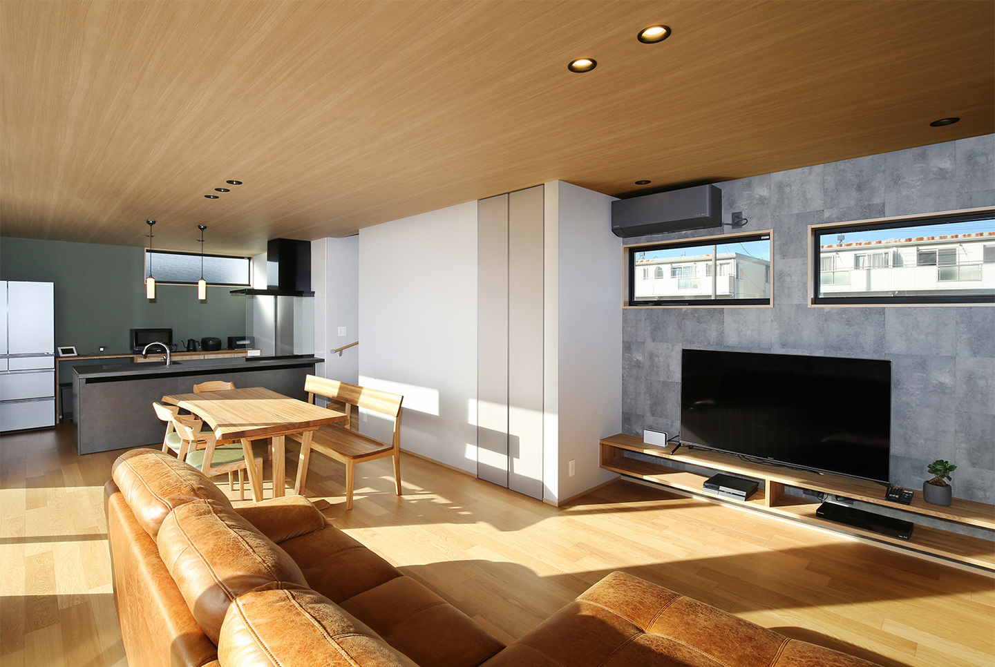 木目の天井とグレーの配色が映えるLDK