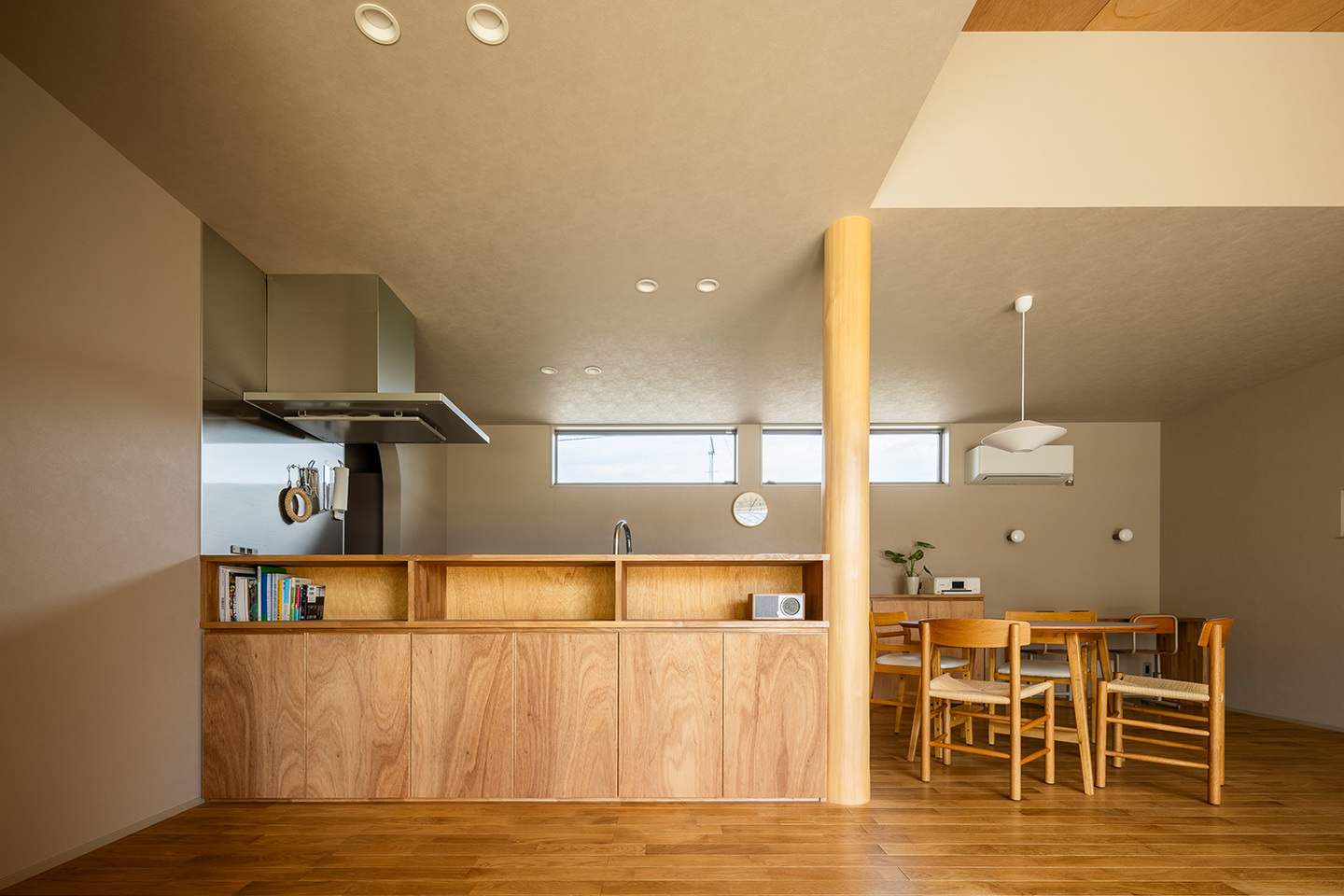 リビング天井のラワン合板と合わせた造作キッチン前収納
