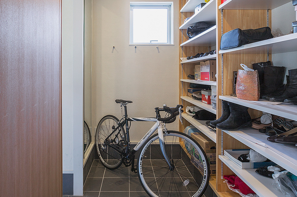 右側壁いっぱいの収納棚と自転車がある部屋